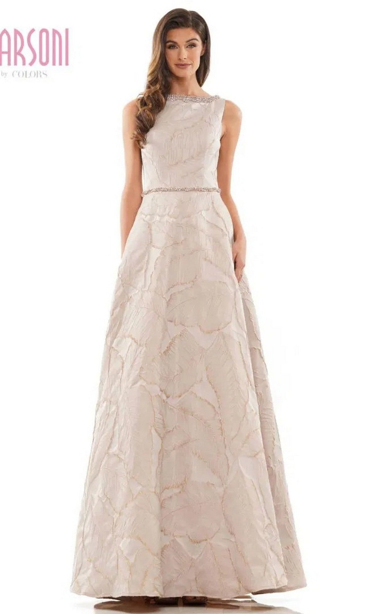 A woman wears the Marsoni MV1224 long formal dress in taupe, featuring a sleeveless jacquard print, fitted bodice, and flared full-length skirt.
